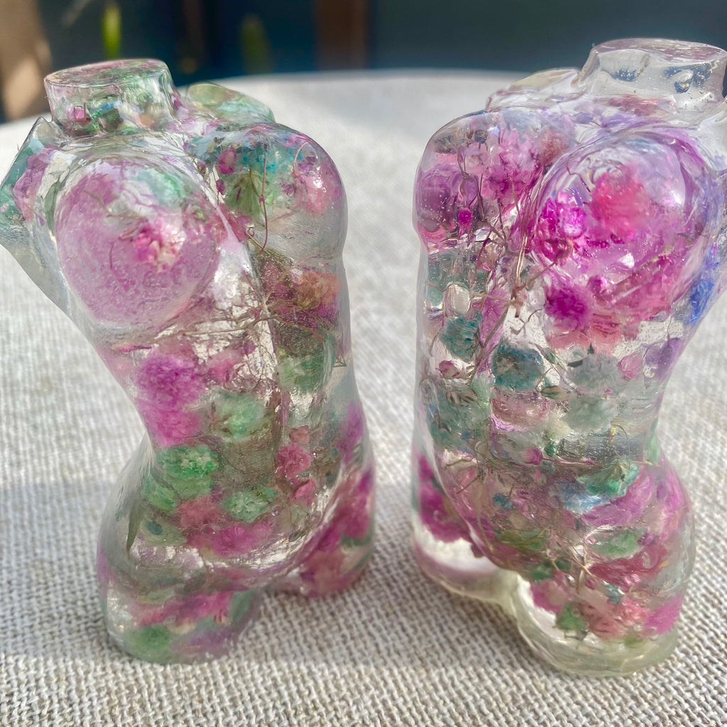 Two Mini women's torso statues filled with colorful flowers