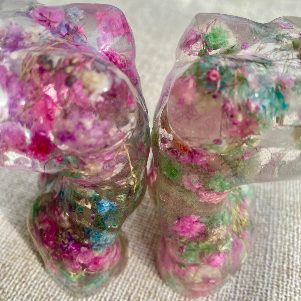 Two Mini women's torso statues filled with colorful flowers