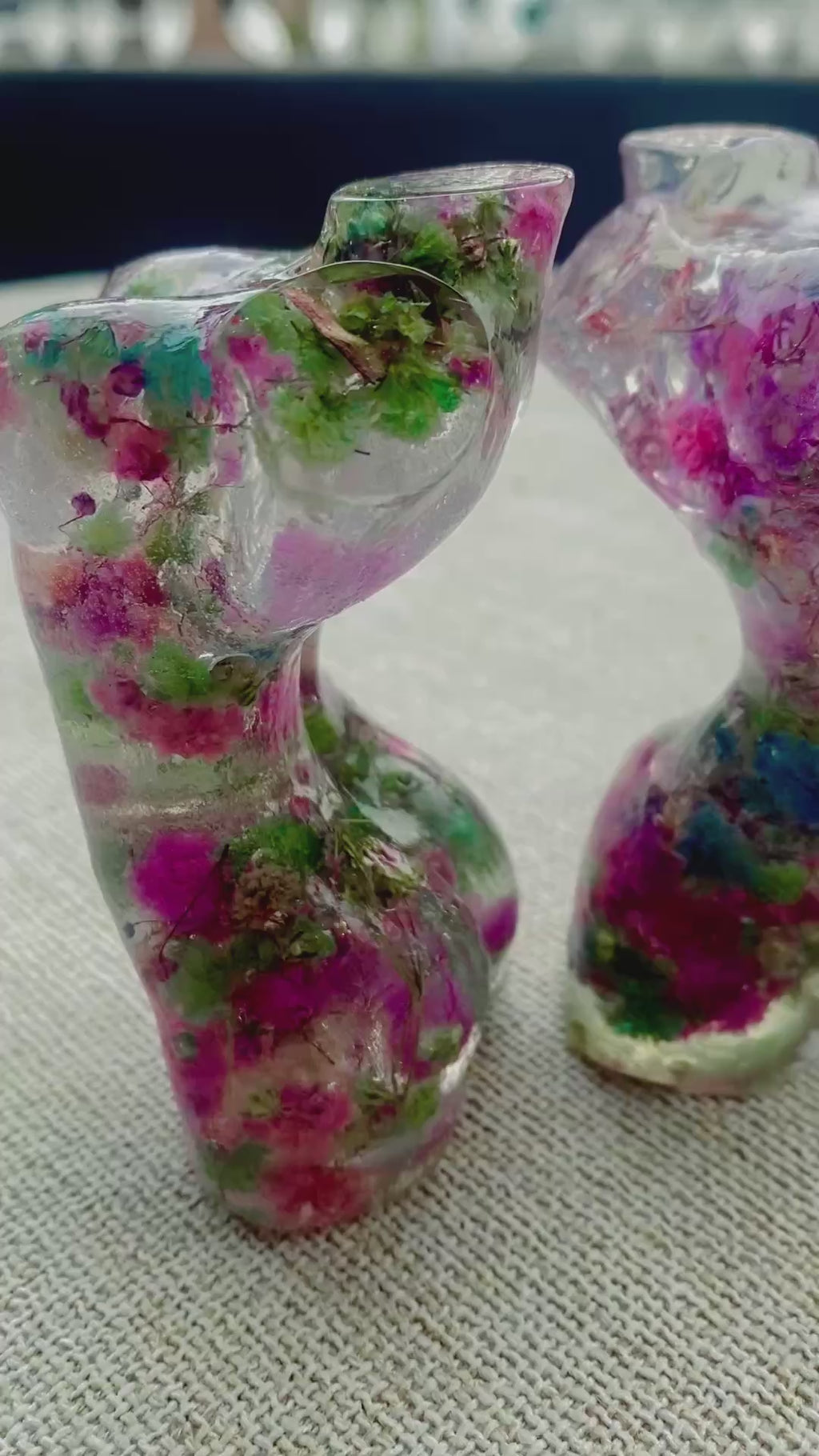 Two Mini women's torso statues filled with colorful flowers