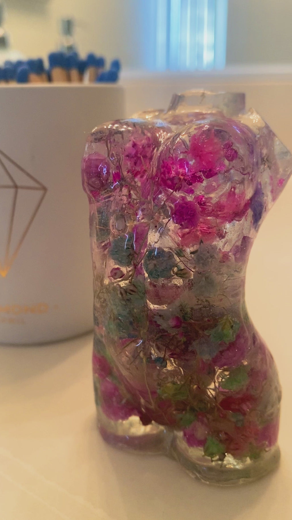 Two Mini women's torso statues filled with colorful flowers